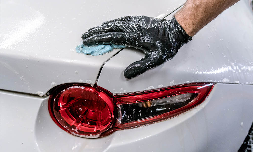 Photo of a person using a Soft99 QJUTSU Clay Bar to clean the car's paintwork from metalic deposits and other deep-seated dirt.