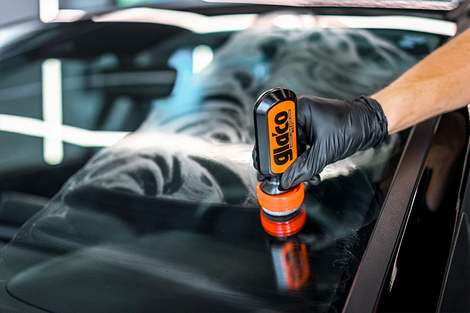 Photo of a Soft99 glass coating Ultra Glaco being applied to a car's windscreen.