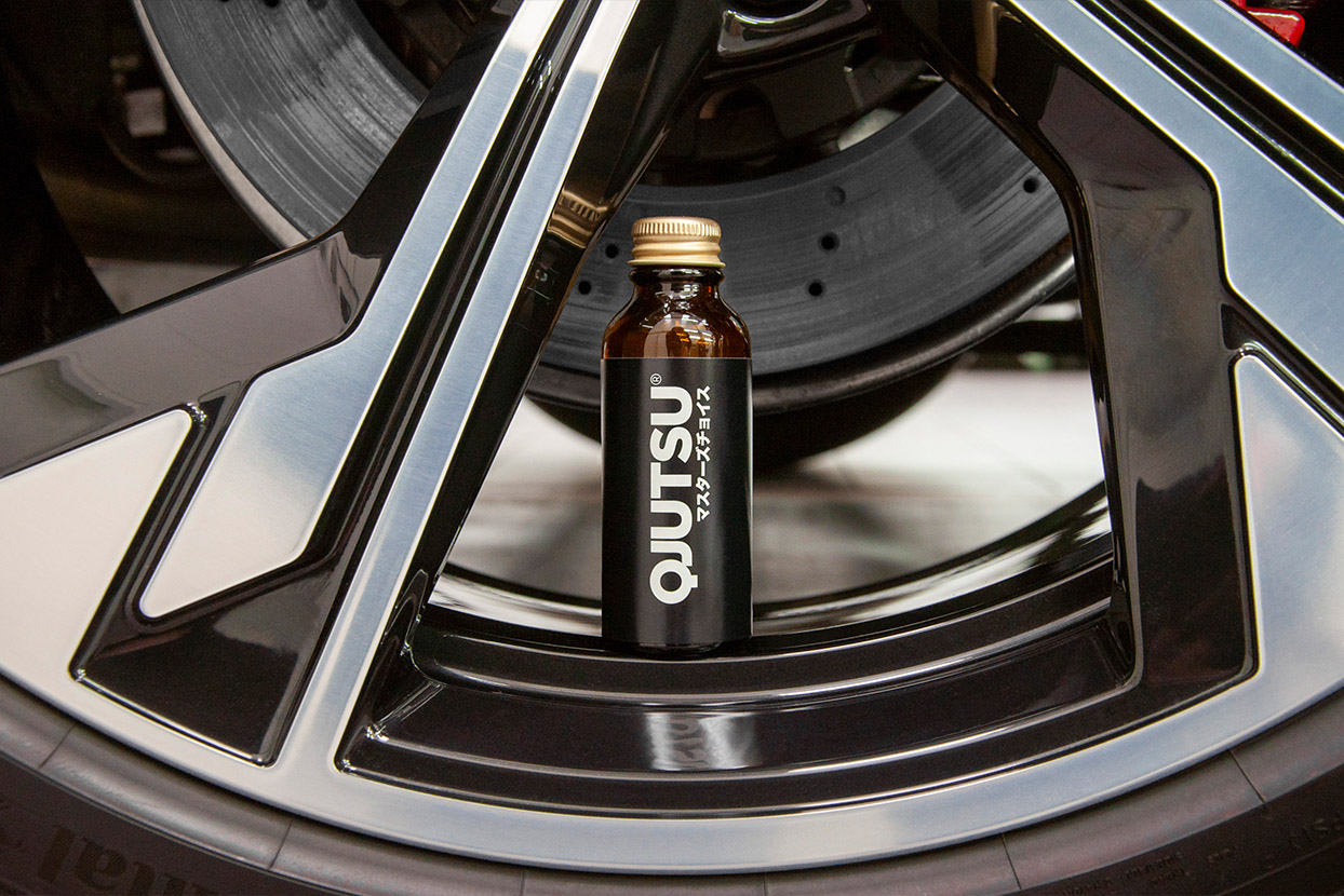 Photo of a bottle of QJUTSU Wheel Coat quartz coating put inside a car's rim.