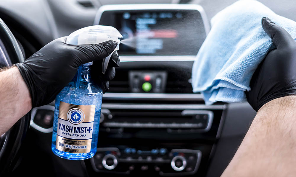 A photo of a Soft99 car care product Wash Mist being applied on the car's dashboard.