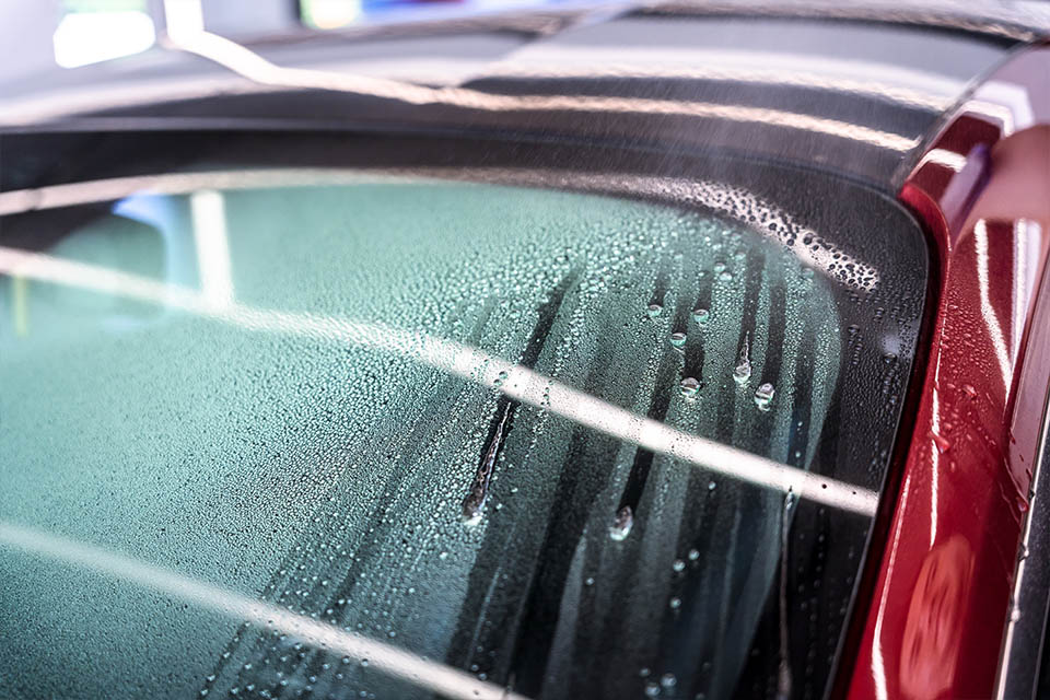 Soft99 Ultra Glaco glass coating. Photo depicts water being repelled of the surface of the windscreen, showing effectiveness of rain-repelling and vision-enhnacing Glaco glass coating.